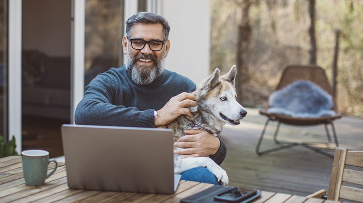 man at computer with dog