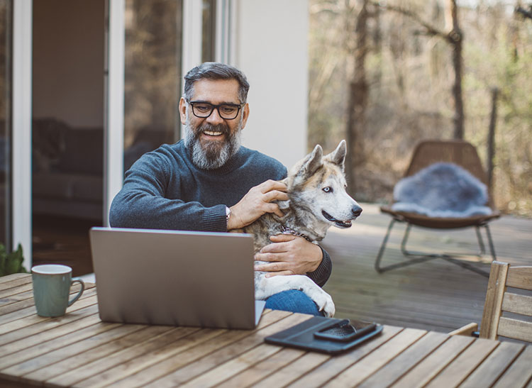 man at computer with dog