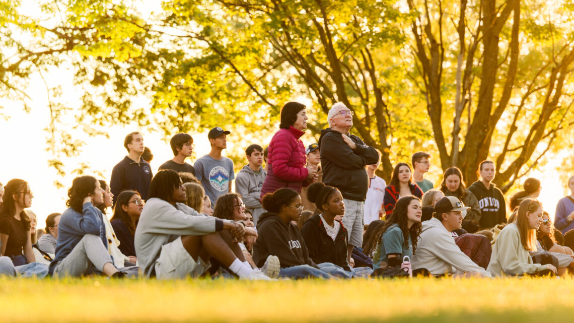 Photo of Buell and Kathy Fogg singing with students during a vespers at Holmes Lake Park.