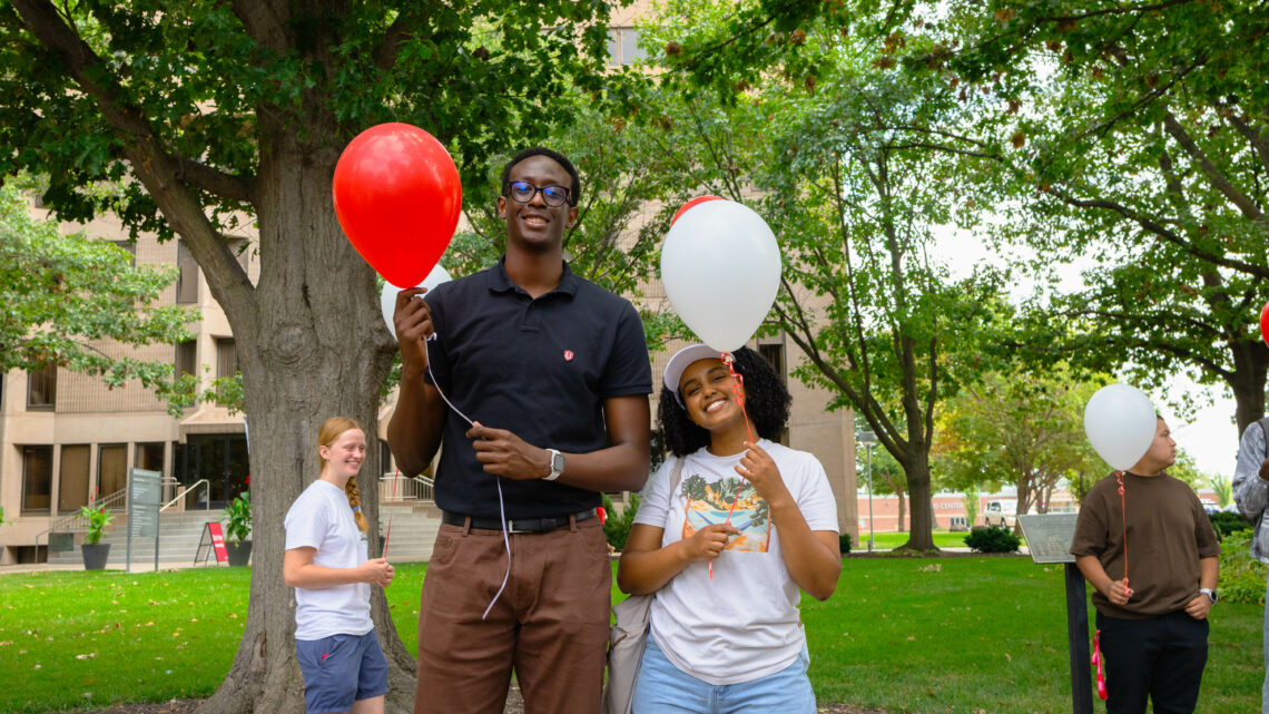 Photo of Yann Birasa and Umeran Waktole holding balloons.