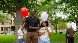 Photo of Yann Birasa and Umeran Waktole holding balloons.