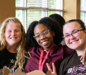 Photo of students Lanai Sanford, Katie Miller and Natalia Leffler eating in the cafeteria.
